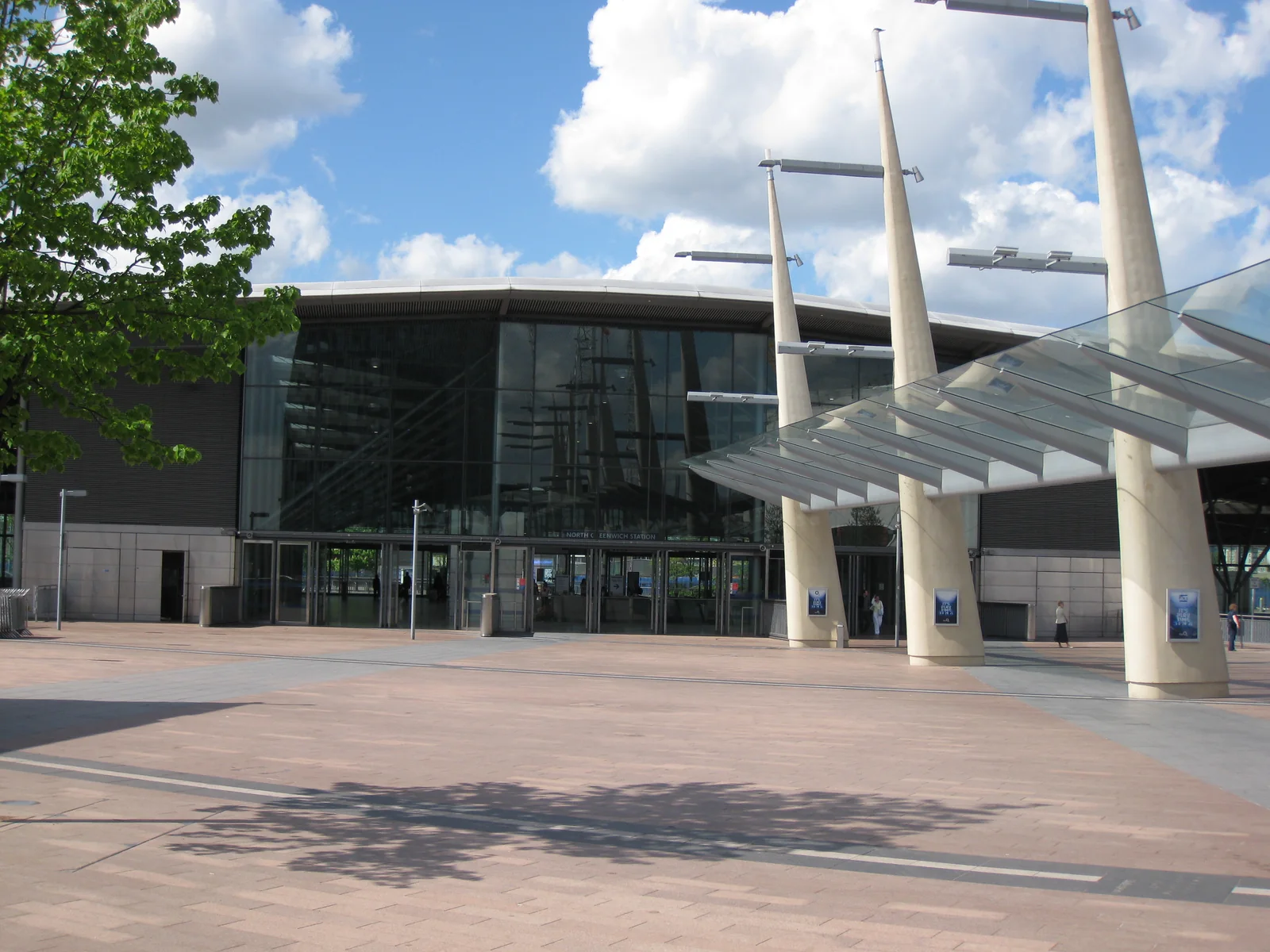 The glass-fronted North Greenwich station behind the canopy and paving of Peninsula Square